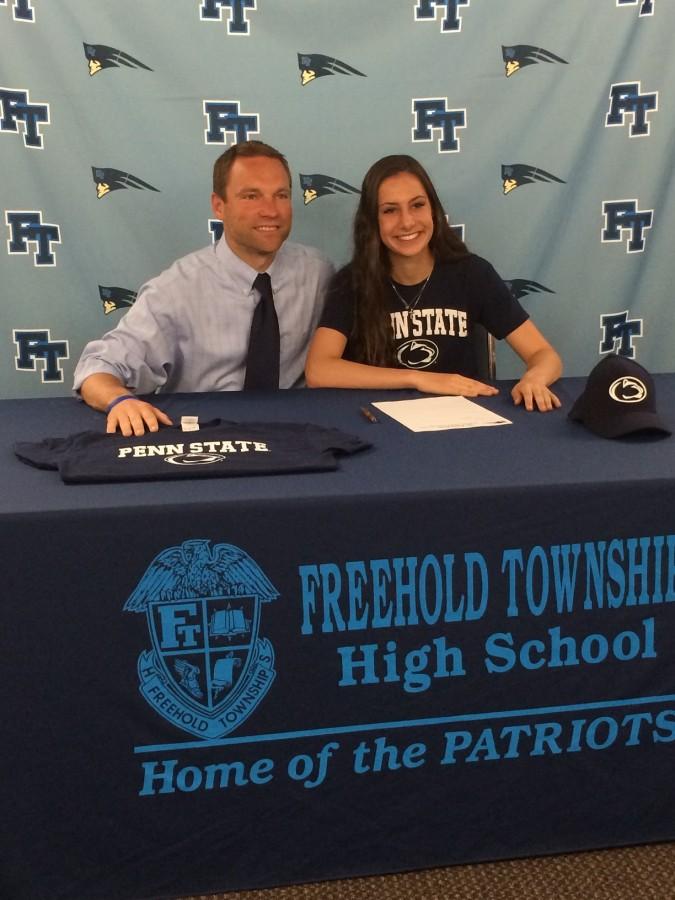 Coach Briggs and Catie Poss pose as Catie signs her letter of intent with Penn State