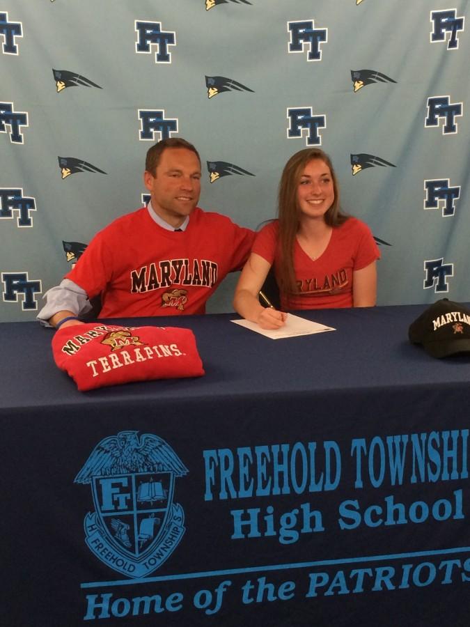 Coach Briggs and Emily Bracher pose as Emily signs her intent to run for University of Maryland