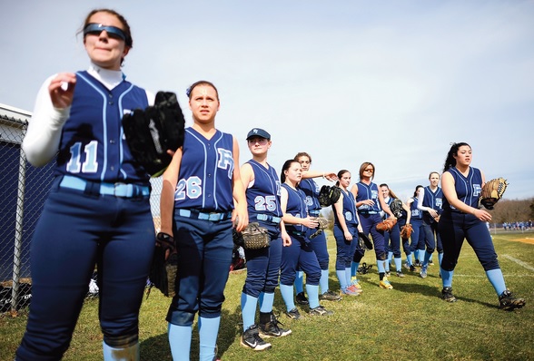 softball players go through their pre-game warmup prior to playing their season opener against Howell High School on April 2