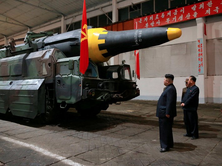 Kim Jong Un examining one of his growing arsenal of missiles 